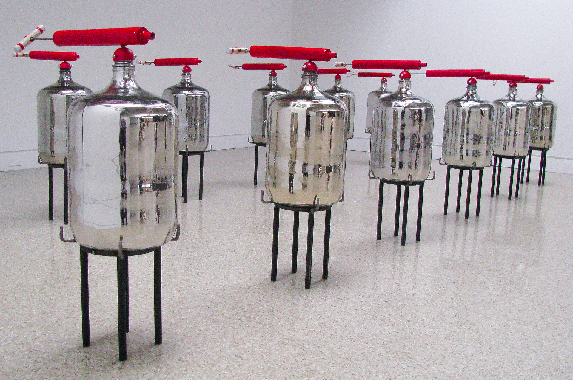 Installation of 12 silvered and engraved vessels with large red sprayer. 